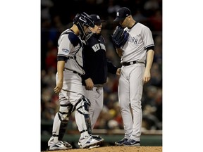 New York Yankees starting pitcher J.A. Happ talks to pitching coach Larry Rothschild during the third inning of Game 1 of a baseball American League Division Series against the Boston Red Sox on Friday, Oct. 5, 2018, in Boston.