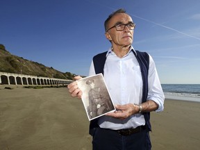 British filmmaker  Danny Boyle holds a photograph of Private Walter Bleakley, who lived on the same street where Boyle went to school, as he announces plans for his Armistice Day commission for 14-18 NOW, the UK's arts programme for the First World War centenary, on the beach, in Folkestone, England, Friday Oct. 5, 2018. Boyle is urging thousands of people to gather on British beaches and make silhouettes in the sand on Nov. 11 to mark 100 years since the end of World War I. Artists will also create giant portraits of people killed in the war, which will be washed away by the incoming tide. The commemoration caps four years of cultural activities marking the centenary of the 1914-18 conflict, in which 20 million people died.