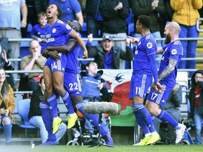 Cardiff City's Bobby Reid, left, celebrates scoring his side's second goal of the game with teammates Souleymane Bamba, second left, Josh Murphy, and Aron Gunnarsson, during the English Premier League soccer match between Cardiff City and Fulham, at the Cardiff City Stadium, in Cardiff, Wales, Saturday, Oct. 20, 2018.