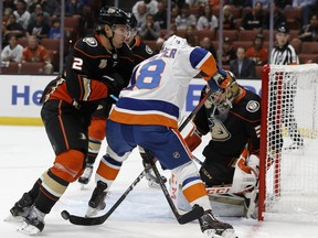 Anaheim Ducks defenseman Luke Schenn, left, collides with New York Islanders center Anthony Beauvillier, center, to displace him from the puck, in front of goalie goaltender John Gibson, right, during the first period of an NHL hockey game in Anaheim, Calif., Wednesday, Oct. 17, 2018.