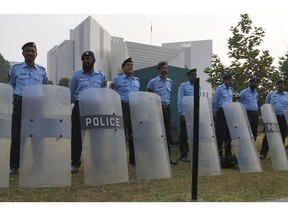 Pakistani police officers stand guard outside the supreme court in Islamabad, Pakistan, Wednesday, Oct. 31, 2018. Pakistan's top court acquitted a Christian woman who has been on death row since 2010 for insulting Islam's Prophet Muhammad. In Wednesday's verdict, the court ordered authorities to free Asia Bibi.