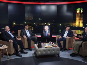 Friends, from left, Amro Darraj, Mohammed Kheir Moussa, Yasin Aktay and Azzam Tamimi gathered around an empty chair with a picture of Saudi writer Jamal Khashoggi placed on it, center, and speak during a live television program for London-based TV station al-Hewar, in Istanbul, late Thursday, Oct. 11, 2018. Khashoggi was supposed to appear on the show. The TV presenter Azzam Tamimi, a prominent Palestinian and a good friend of Khashoggi, told The Associated Press that the program was planned to discuss his new projects, his books and other issues.