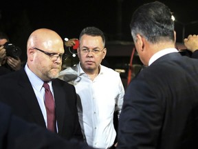 Pastor Andrew Brunson, center, and U.S. Charge d'Affaires Jeffrey Hovenier, left, arrive at Adnan Menderes airport for a flight to Germany after his release following his trial in Izmir, Turkey, Friday, Oct. 12, 2018, A Turkish court on Friday convicted an American pastor of terror charges but released him from house arrest and allowed him to leave Turkey, in a move that is likely to ease tensions between Turkey and the United.