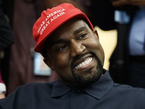 Rapper Kanye West smiles as he listens to a question from a reporter during a meeting in the Oval Office of the White House with President Donald Trump, Thursday, Oct. 11, 2018, in Washington.