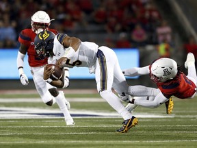 California quarterback Brandon McIlwain (5) is tackled by Arizona safety Demetrius Flannigan-Fowles (6) during the first half of an NCAA college football game Saturday, Oct. 6, 2018, in Tucson, Ariz.