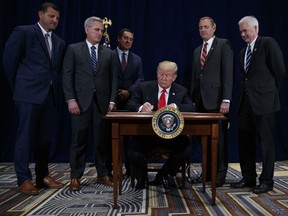 President Donald Trump signs a "Presidential Memorandum Promoting the Reliable Supply and Delivery of Water in the West," during a ceremony, Friday, Oct. 19, 2018, in Scottsdale, Ariz. Standing behind the president from left, Rep. David Valadao, R-Calif., Majority Leader Kevin McCarthy, R-Calif., Rep. Devin Nunes, R-Calif., Rep. Jeff Denham, R-Calif., and Rep. Tom McClintock, R-Calif..