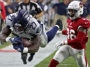 Seattle Seahawks running back Mike Davis (27) dives in for a touchdown as Arizona Cardinals defensive back Budda Baker (36) defends during the first half of an NFL football game, Sunday, Sept. 30, 2018, in Glendale, Ariz.