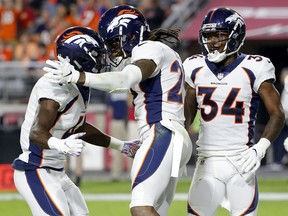 Denver Broncos cornerback Bradley Roby celebrates his touchdown against the Arizona Cardinals with cornerback Isaac Yiado, left, and defensive back Will Parks (34) during the second half of an NFL football game, Thursday, Oct. 18, 2018, in Glendale, Ariz.