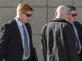 FILE - In this March 21, 2018, file photo, Border Patrol agent Lonnie Swartz, left, arrives at U.S. District Court in downtown Tucson, Ariz., where opening arguments began in his murder trial in Tucson. Swartz will face a second trial Tuesday, Oct. 23, 2018, in the killing of a 16-year-old Mexican teen across the international border. Swartz was acquitted of second-degree murder in Tucson earlier in the year and now will be tried on voluntary and involuntary manslaughter charges.