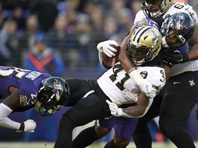 New Orleans Saints running back Alvin Kamara (41) is tackled by Baltimore Ravens cornerback Tavon Young, left, and linebacker Tim Williams as he rushes the ball in the second half of an NFL football game, Sunday, Oct. 21, 2018, in Baltimore.