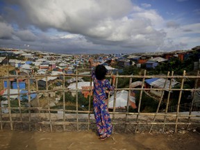 In this Aug. 26, 2018, photo, a Rohingya refugee girl stands by a fence at Kutupalong refugee camp, Bangladesh. More than half a million Rohingya children live in the congested camps. They rely on 1,200  learning centers set up by aid organizations that can't accommodate everyone and only offer classes up to a 5th-grade level.