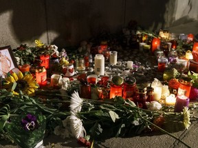 A portrait of slain television reporter Viktoria Marinova is placed on the Liberty Monument next to flowers and candles during a vigil in Ruse, Bulgaria, Tuesday, Oct. 9, 2018. Bulgarian police are investigating the rape, beating and slaying of a Marinova, whose body was dumped near the Danube River after she reported on the possible misuse of European Union funds in Bulgaria. Authorities discovered the body of 30-year-old Viktoria Marinova on Saturday in the northern town of Ruse near the Romanian border. One Bulgarian media site demanded an EU investigation, fearing that Bulgarian officials were complicit in the corruption.