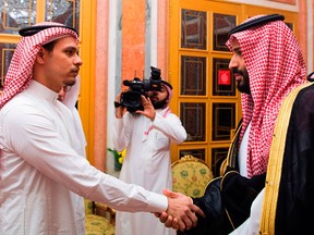 Saudi Crown Prince Mohammed bin Salman, right, shakes hands with Salah Khashoggi, a son of slain journalist Jamal Khashoggi, in Riyadh, Saudi Arabia, on Oct. 23, 2018, in a photo released by the Saudi Press Agency, SPA.