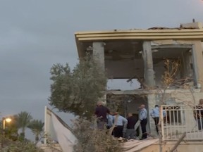 In this image made from video, police inspect the damage to a building from a rocket, Wednesday, Oct. 17, 2018, in Beersheba, Israel. The Israeli military says a rocket fired from Gaza made a direct hit on a home in southern Israel. It's the first rocket attack against Israel in months and the first that hit an Israeli home in Beersheba since the 2014 war between Israel and Gaza's militant Hamas rulers. (KAN via AP)