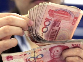 In this photo taken on Aug. 25, 2010, a bank clerk counts Chinese 100 Yuan notes in Shanghai. China's politically sensitive yuan has sunk to a 22-month low against the dollar after the U.S. Treasury declined to label Beijing a currency manipulator amid a mounting tariff battle.