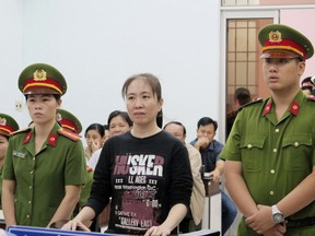 FILE - In this Thursday, Nov. 30, 2017, file photo, Nguyen Ngoc Nhu Quynh, center, a prominent Vietnamese blogger, stands trial in the south-central province of Khanh Hoa, Vietnam. Vietnam has freed a well-known blogger after two years in prison on the condition that she leave for the United States. Nguyen Ngoc Nhu Quynh, known as "Mother Mushroom," was arrested in October 2016 and sentenced to 10 years in prison on charges of defaming the Communist government.