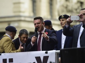 Former English Defence League (EDL) leader Tommy Robinson addresses his supporters as he arrives at the Old Bailey where he is accused of contempt of court, in London, Tuesday, Oct. 23, 2018.