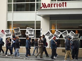 FILE - In this Oct. 4, 2018 file photo, hotel workers strike in front of a Marriott hotel in San Francisco. New technology threatening to make some hotel jobs obsolete is among the concerns prompting thousands of Marriott workers to walk off their jobs across the U.S. in recent weeks.