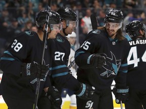 San Jose Sharks' Joonas Donskoi (27) celebrates with Timo Meier, left, and Erik Karlsson (65) after scoring a goal against the Buffalo Sabres during the first period of an NHL hockey game Thursday, Oct. 18, 2018, in San Jose, Calif.