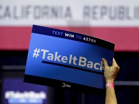 In this Thursday, Oct. 4, 2018, photo a supporter holds up a sign for Gil Cisneros, a candidate who is running for a U.S. House seat in the 39th District in California, at a rally on the Cal State Fullerton campus in Fullerton, Calif. For decades, Orange County, California, was known as a Republican stronghold but times have changed. A sign of the change is in the 39th District, where, Young Kim, a Korean immigrant Republican is running against Cisneros, a Hispanic Democrat.