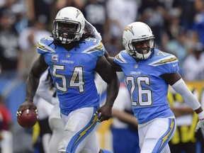 Los Angeles Chargers defensive end Melvin Ingram, left, celebrates his interception with teammate cornerback Casey Hayward during the second half of an NFL football game against the Oakland Raiders Sunday, Oct. 7, 2018, in Carson, Calif.