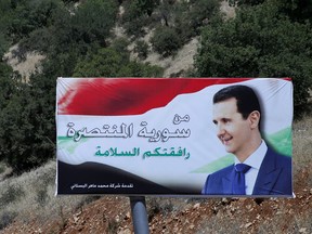 FILE - In this July 20, 2018 file photo, a poster of Syrian President Bashar Assad with Arabic that reads "Welcome in victorious Syria," is displayed on the border between Lebanon and Syria. Assad told a little-known Kuwaiti newspaper that Syria has reached a "major understanding" with other Arab states after years of hostility over the country's civil war. The interview published Wednesday, Oct. 3, 2018, in the Al-Shahed newspaper, was Assad's first with a Gulf newspaper since the war began in 2011.