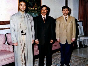 FILE - In this undated file photo, Iraqi ruler Saddam Hussein poses with his two sons Oday, left, and Qusay. Uday was feared and reviled for his violent, maniacal and unbalanced tendencies and was accused of multiple rapes. The quieter Qusay was thought to be Saddam's preference to succeed him. The killing of Saudi writer Jamal Khashoggi in Istanbul by agents believed to be close the kingdom's Crown Prince Mohammed bin Salman has cast him into the ruthless and pitiless pantheon of sons of the Arab World's most infamous tyrants. (AP Photo, File)