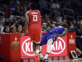 Houston Rockets' James Harden, left, collides with Los Angeles Clippers' Patrick Beverley during the first half of an NBA basketball game Sunday, Oct. 21, 2018, in Los Angeles.