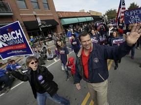 FILE - In this Sept. 29, 2018 file photo, Republican candidate for Kansas Governor, Kris Kobach waves at people during the Overland Park fall festival parade in Overland Park, Kan. A new television ad in the Kansas gubernatorial race hits Republican Kris Kobach for his past comments on state school funding.