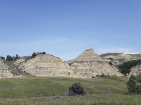 FILE - This Aug. 1, 2018, file photo, shows a view of the badlands landscape at Theodore Roosevelt National Park near Medora, N.D. Environmental groups opposing the site of an oil refinery being developed near Theodore Roosevelt National Park in North Dakota want a judge to reconsider his recent recommendation that state regulators dismiss the groups' challenge. They accuse the Davis Refinery developer of not updating state officials about revisions to the project. Meridian Energy Group says it had no reason or requirement to do so.