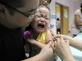 In this Sept. 11, 2010 file photo, a child cries while receiving a shot of measles vaccine at a health station in Hefei in central China's Anhui province.