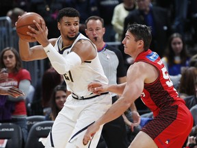 FILE--In this Friday, Oct. 5, 2018, file photograph, Denver Nuggets guard Jamal Murray, left, looks to pass the ball as Perth guard Damian Martin defends in the first half of a preseason basketball game in Denver.