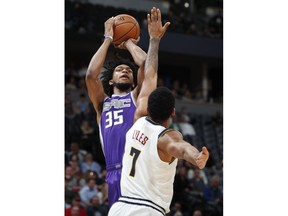 Sacramento Kings forward Marvin Bagley III, back, shoots over Denver Nuggets forward Trey Lyles in the first half of an NBA basketball game, Tuesday, Oct. 23, 2018, in Denver.