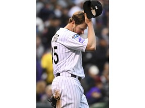 Colorado Rockies relief pitcher Scott Oberg reacts after throwing a wild pitch to allow Milwaukee Brewers' Erik Kratz to score from third base in the sixth inning of Game 3 of a baseball National League Division Series, Sunday, Oct. 7, 2018, in Denver.