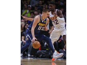 Denver Nuggets center Nikola Jokic (15) drives past Phoenix Suns center Deandre Ayton (22) during the first quarter of an NBA basketball game, Saturday, Oct. 20, 2018, in Denver.