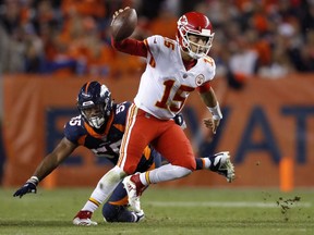 Kansas City Chiefs quarterback Patrick Mahomes (15) avoids the hit by Denver Broncos linebacker Deiontrez Mount (53) during the second half of an NFL football game, Monday, Oct. 1, 2018, in Denver.