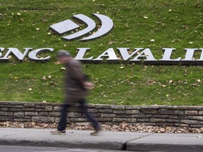 A man walks past the headquarters of SNC-Lavalin in Montreal on November 6, 2014. SNC-Lavalin Group Inc. says it won't be "invited" to negotiate a remediation agreement with federal prosecutors at this time, but it will continue to operate as it has since the RCMP laid charges against the company in 2015.THE CANADIAN PRESS/Paul Chiasson