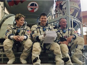 Astronauts Anne McClain, left to right, from the United States, Oleg Kononenko from Russia and David Saint-Jacques from Canada sit after exiting the Soyuz simulator after an exercise at the Gagarin Cosmonaut Training Center in Star City, Russia, on Friday, Aug. 17, 2018. Russian space officials say they hope to resume sending crews to the International Space Station on Dec. 3 after an October launch failed because of a technical malfunction.