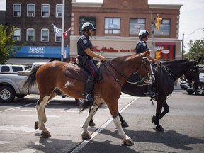 Mounted police patrol Danforth Avenue where a shooting took place on Sunday evening, in Toronto on Monday, July 24, 2018. Toronto's police service is set to expand an existing neighbourhood officer program in an effort to "build trust and reduce crime," but critics say it's unlikely to do either.