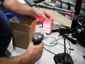 A worker scans a package of cannabis products at the Ontario Cannabis Store distribution centre in an undated handout photo.