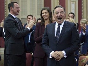 Quebec Premier Francois Legault, right, reacts after he and his cabinet were sworn in during a ceremony at the National Assembly Thursday, October 18, 2018 at the legislature in Quebec City.