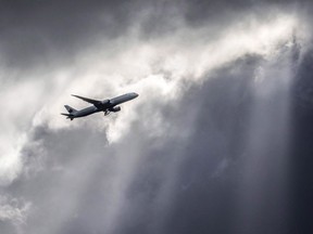 An Air Canada plane flies underneath dark clouds illuminated by some sun rays above Frankfurt, Germany, Thursday, March 2, 2017. The legalization of recreational marijuana next week is reopening old wounds and sparking new battles between employers and employees in high-risk jobs that could wind up in the court system. A recent decision by Air Canada to prohibit all employees in flight operations and aircraft maintenance from using cannabis at all times, both on-duty and off-duty, has raised eyebrows on both sides of the debate.