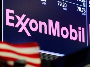 The logo for ExxonMobil appears above a trading post on the floor of the New York Stock Exchange, Monday, April 23, 2018. A lawsuit launched this week in a U.S. court says ExxonMobil has dramatically underestimated the risks its oilsands assets face from efforts to reduce carbon emissions.