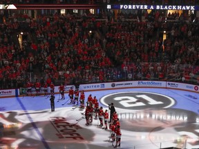 Chicago Blackhawks players watch a tribute in the memory of the Hall of Famer Stan Mikita before an NHL hockey game, against the Toronto Maple Leafs Sunday, Oct. 7, 2018, in Chicago. Mikita, died August 7th at the age of 78 after a long illness.