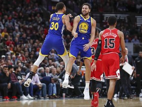 Golden State Warriors guard Klay Thompson, center, celebrates with guard Stephen Curry, left, after scoring against the Chicago Bulls during the first half of an NBA basketball game, Monday, Oct. 29, 2018, in Chicago.