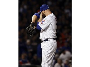 Chicago Cubs starting pitcher Jon Lester wipes his face after Colorado Rockies' DJ LeMahieu hit a ground-rule double during the first inning of the National League wild-card playoff baseball game Tuesday, Oct. 2, 2018, in Chicago.