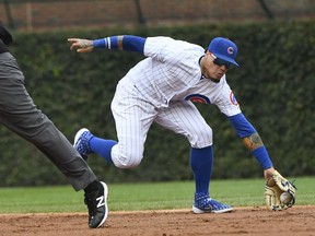 Chicago Cubs shortstop Javier Baez (9) fields a ball hit by Milwaukee Brewers' Lorenzo Cain (6) during the third inning of a tie break baseball game on Monday, Oct. 1, 2018, in Chicago. Baez threw to first for the out.