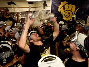 Milwaukee Brewers relief pitcher Josh Hader, center, and other players celebrate in the club house after defeating the Chicago Cubs 3-1 in a tiebreak baseball game on Monday, Oct. 1, 2018, in Chicago.