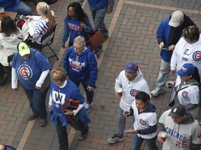 Fans head to the ballpark before the National League wild-card playoff baseball game between the Chicago Cubs and the Colorado Rockies, Tuesday, Oct. 2, 2018, in Chicago.