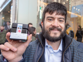 Matthew Geahal holds up his purchase in front of a government cannabis store in Montreal, Oct. 17, 2018 as the legal sale of marijuana begins in Canada.